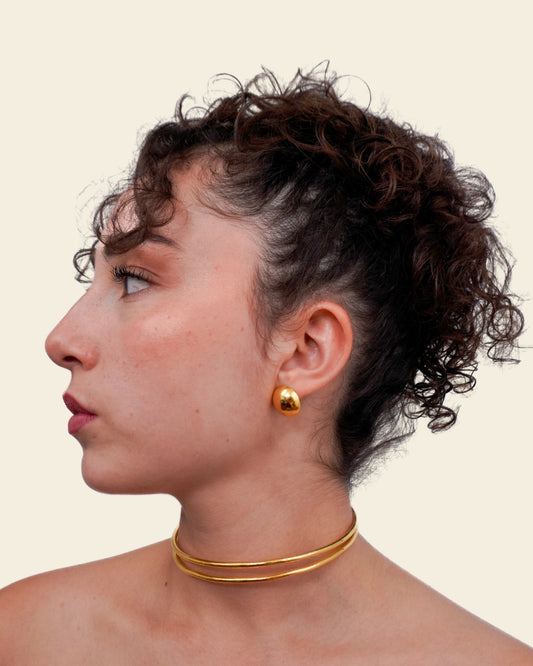 Woman wearing gold earrings and necklaces against a beige background
Handcrafted bronze accessory with 24K gold plating
Inspired by ancient jewelry A timeless piece that connects past and present.
Show your style with Zipa and tag us @bokdi.eu!