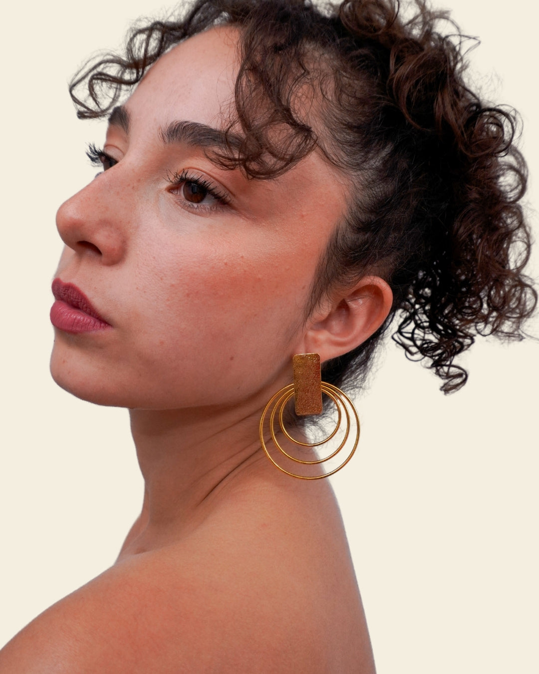 Woman wearing gold hoop earrings on a beige background
Handcrafted bronze accessory with 24K gold plating

Inspired by ancient jewelry showcased at the Bogotá Museum of Gold. A timeless piece that connects past and present.

Show your style with Zipa and tag us @bokdi.eu! 